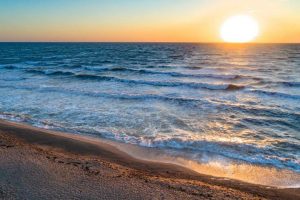 Playa de mar, con la puesta de sol.